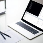 Laptop with purchase order form on a desk.