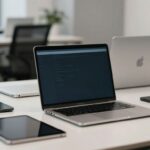 Laptops and tablets on a desk for remote device management.